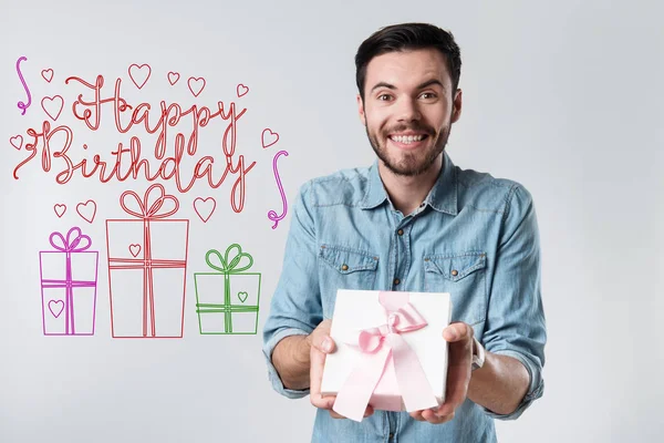 Emocionální mladý muž, který držel dárek je na narozeninové party — Stock fotografie