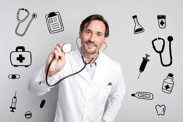 Usmívající se zdravotnický pracovník hledá příjemný podržíte stetoskop — Stock fotografie