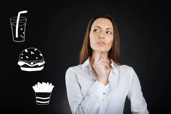 Thoughtful woman touching her chin while choosing food in a cafe — Stock Photo, Image