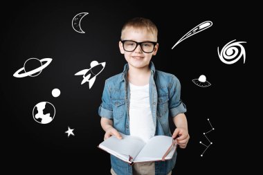 Boy bardaklarda yer hakkında öğrenme sırasında bir defter tutan gülümseyerek