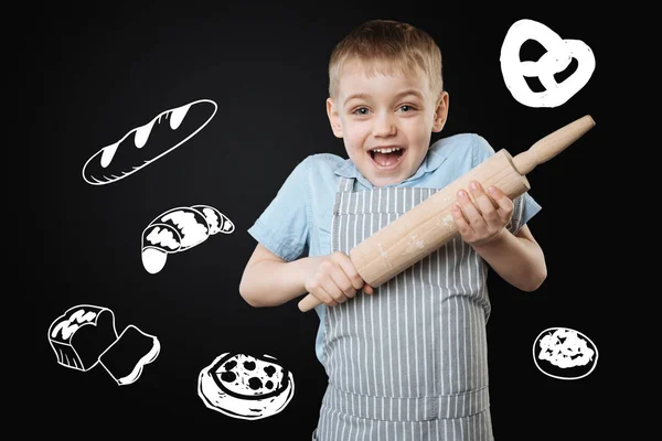 Emotionaler Junge mit Nudelholz und aufgeregtem Gemüt beim Kochen — Stockfoto