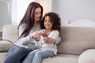 Mutlu anne ve kızı kanepede oturan