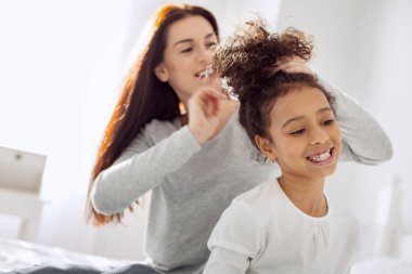 Mutlu anne kızı için bir saç modeli yaptırıyor