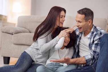 Mutlu anne ve babaları ile oynayan kız
