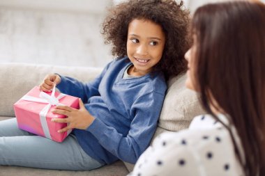 Ona hediye tutarak memnun küçük kız