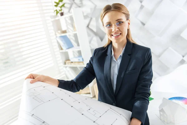 Exuberant smiling engineer holding a drawing — Stock Photo, Image