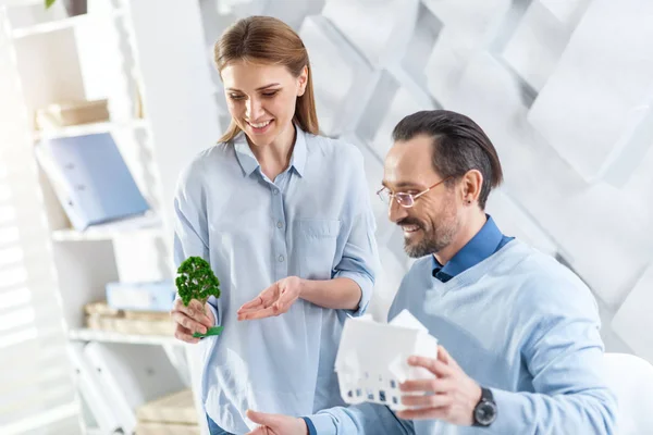 Glückliche Landschaftsgestalter mit einem Haus und Baumminiaturen — Stockfoto