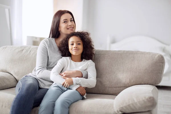 Lycklig mor och dotter placering på soffan — Stockfoto