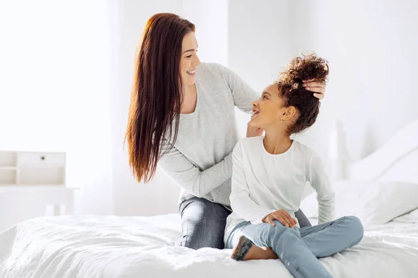 Feliz madre haciendo un peinado para su hija —  Fotos de Stock