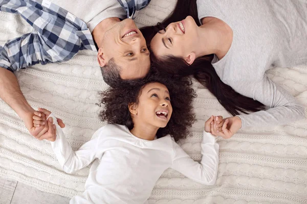 Família feliz deitada juntas no sofá — Fotografia de Stock