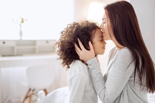 Inspirierte Mutter küsst ihre Tochter — Stockfoto