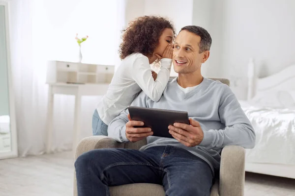 Inspired girl whispering in her dads ear — Stock Photo, Image