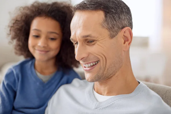 Sonrientes padre e hija sentados juntos — Foto de Stock