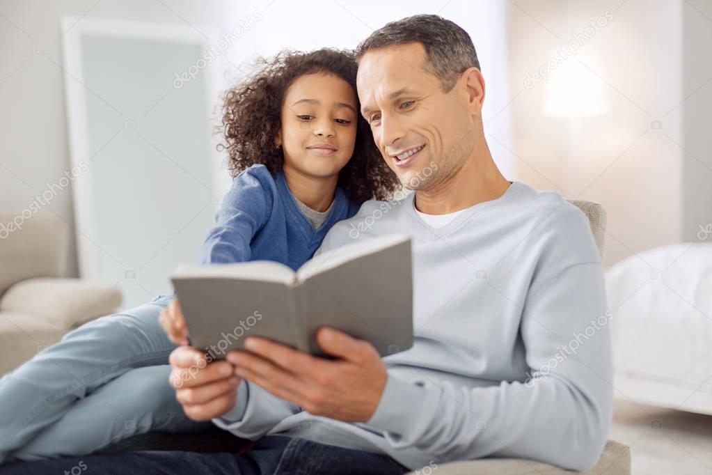 Content father reading a book for his daughter