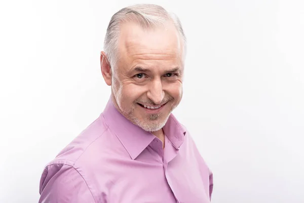 Hombre guapo de pelo gris sonriendo descaradamente mientras posaba — Foto de Stock