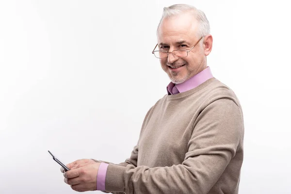 Piacevole uomo anziano in occhiali da vista utilizzando il suo telefono — Foto Stock