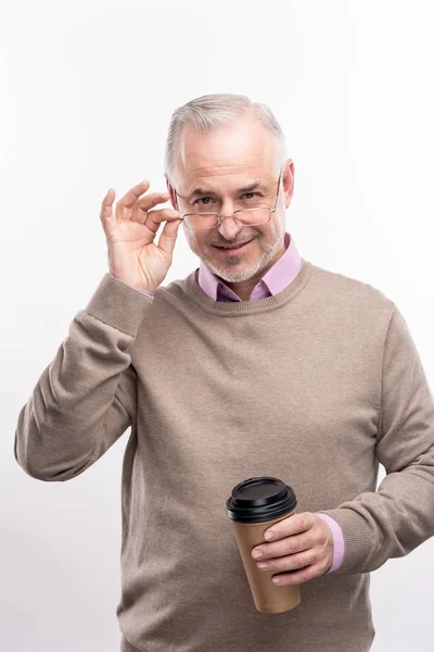 Trevlig gråhåriga mannen poserar med kaffekopp — Stockfoto