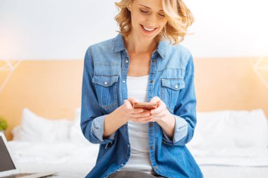 Hoş iletileri okunurken gülümseyen sevimli genç kadın