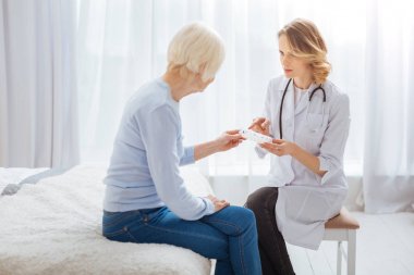 Ciddi profesyonel doktor hastasını hapları hakkında söylüyorum