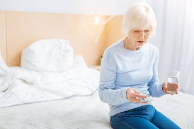 Özenli düşünceli emekli hapları alırken sakin seyir