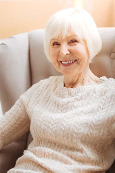 Angenehme fröhliche Rentnerin aufgeregt, während sie auf ihre Verwandten wartet — Stockfoto