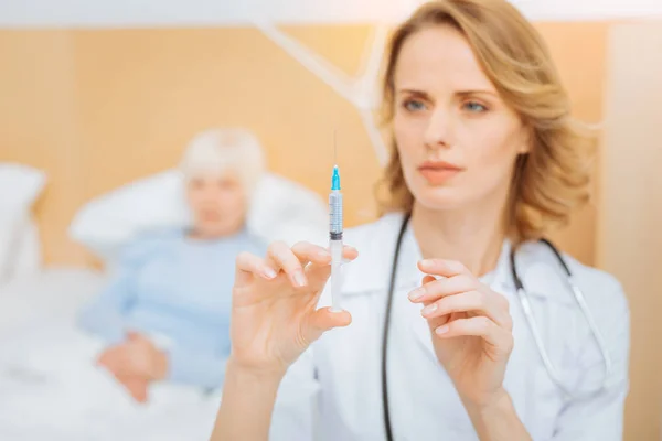 Calm skilled doctor getting ready for making a necessary injection — Stock Photo, Image