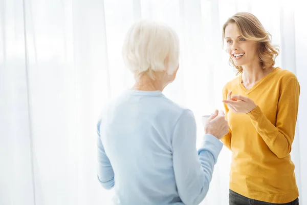 Duas mulheres emocionais envolvidas em uma linda conversa e sorrindo — Fotografia de Stock