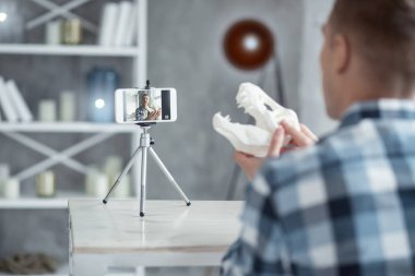 Kararlı blogger bir dinozor kafatası kam gösteriliyor