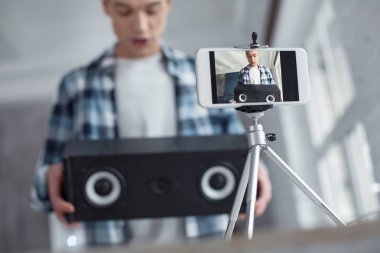 Onun yeni hoparlörler holding neşeli blogger