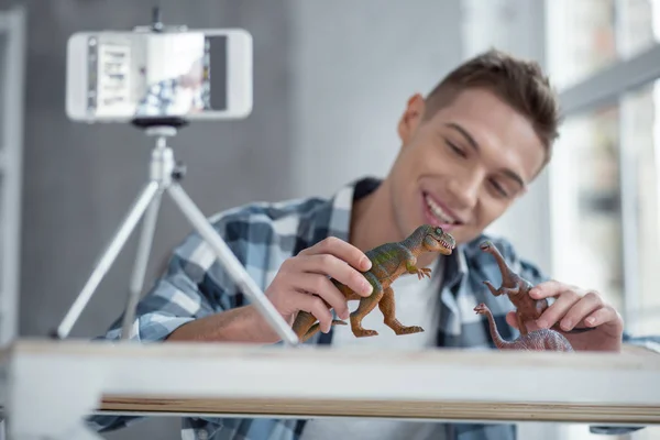 Joyful blogger making a video about his dinosaurs