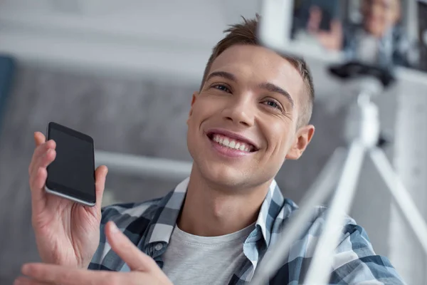 Happy blogger talking about his new phone on cam — Stock Photo, Image