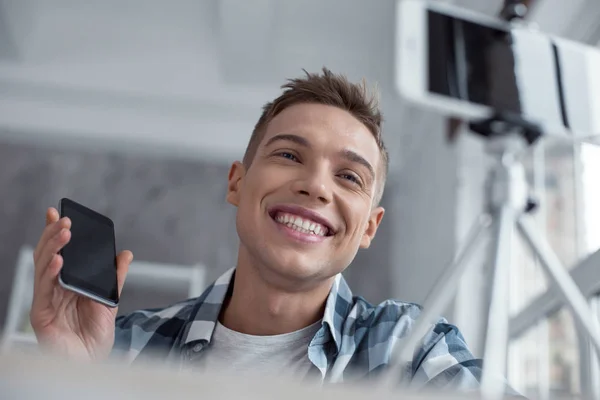 Exuberant blogger talking about his new phone on cam — Stock Photo, Image