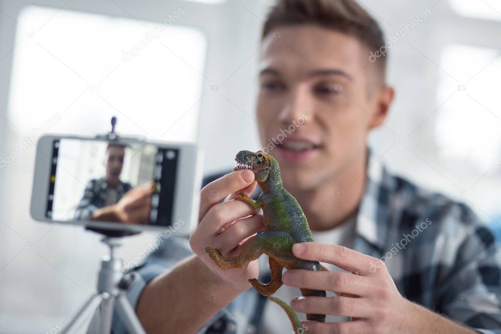 Glad vlogger holding dinosaurs on cam