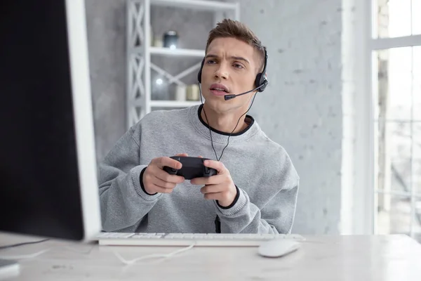 Kararlı genç adam ile bilgisayar oyunu oynamak — Stok fotoğraf