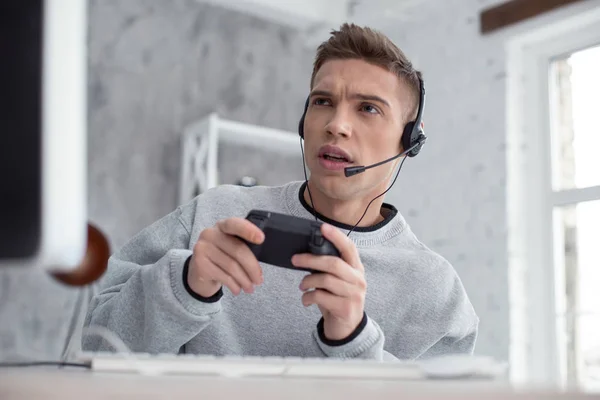 Attentif jeune homme jouer à des jeux informatiques — Photo