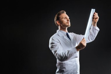 Ayakta ve x-ray tarama bakan dikkatli perspektif doktor.