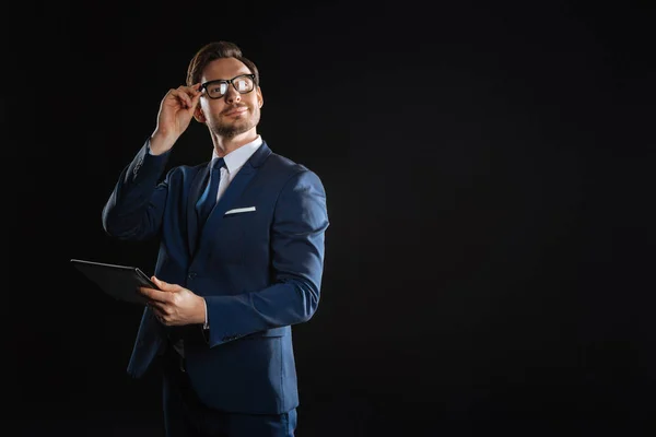 Успешный человек в очках, держащий планшет прикасаясь к своим очкам . — стоковое фото