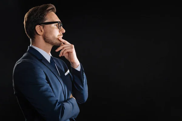 Doordachte gebrild man die opzij aanraken aan zijn kin. — Stockfoto