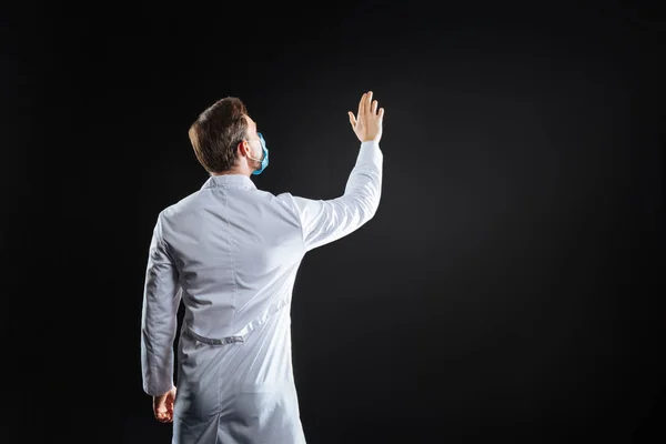 Occupied qualified medic standing and holding hand up. — Stock Photo, Image