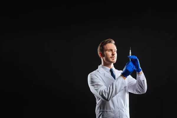 Koncentrerad uppmärksam läkare står och dosering en spruta. — Stockfoto