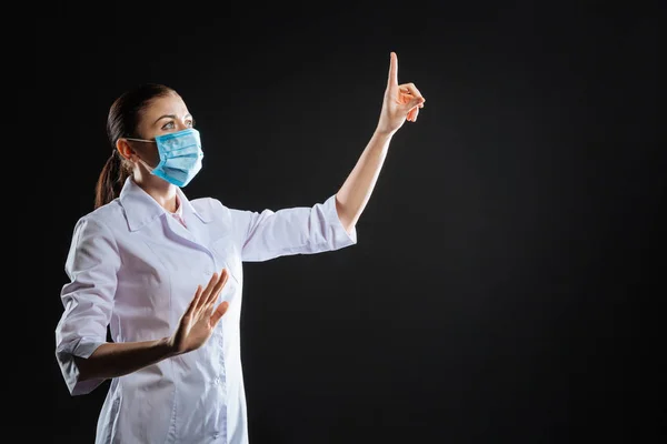Attenta infermiera occupata che guarda verso l'alto toccando il touchscreen invisibile . — Foto Stock
