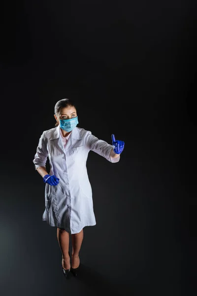 Уверенная квалифицированная медсестра, стоящая и трогательная на невидимом экране . — стоковое фото