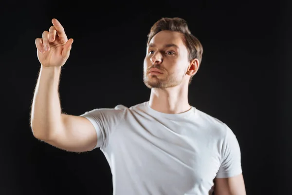 Concentrated calm man standing and pointing aside. — Stock Photo, Image