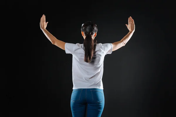 Mujer curiosa interesada levantando las manos y usando gafas VR . — Foto de Stock