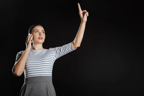 Pretty occupied woman holding hand up and having phone conversation. — Stock Photo, Image