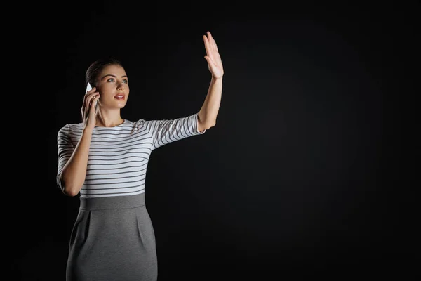 Mujer ocupada atenta levantando la mano y teniendo conversación telefónica . — Foto de Stock