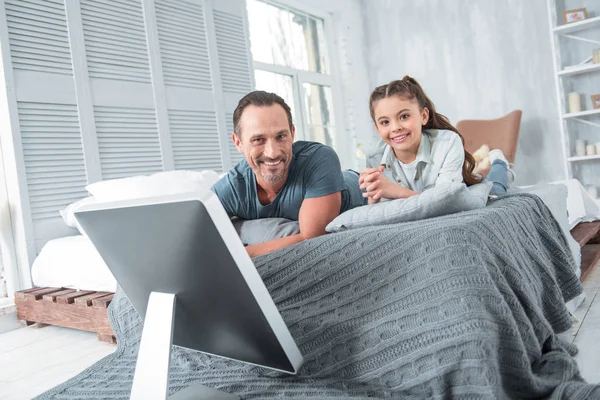 Positivo alegre pai e filha deitados na cama — Fotografia de Stock