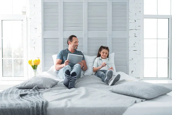 Freudig netter Vater und Tochter, die sich im Bett ausruhen — Stockfoto