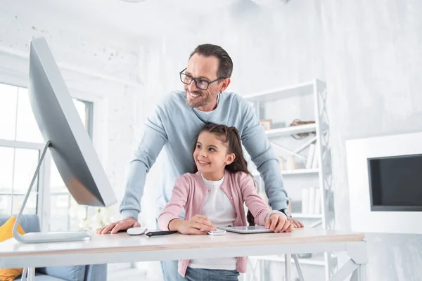 Felice uomo felice aiutando sua figlia — Foto Stock