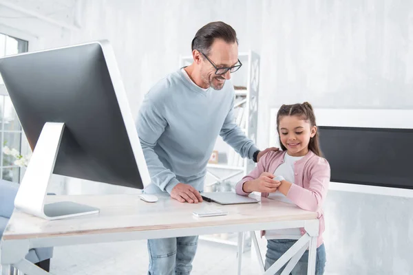 Glad söt tjej tittar på hennes hand — Stockfoto